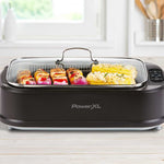 PowerXL Smokeless Grill – Gemüsespieße und Maiskolben unter Glasdeckel gleichmäßig gegrillt.