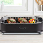PowerXL Smokeless Grill – zwei Rindersteaks mit Rosmarin und Grillgemüse auf gerillter Grillplatte.