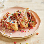 PowerXL Waffle Star – Bunte Waffelstücke mit Streuseln und Zuckerguss, serviert auf einem rosa Teller.