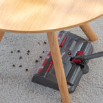 Der Livington Voom saugt mühelos Schmutz unter Möbeln auf – hier auf einem Teppich mit Kaffeebohnen.