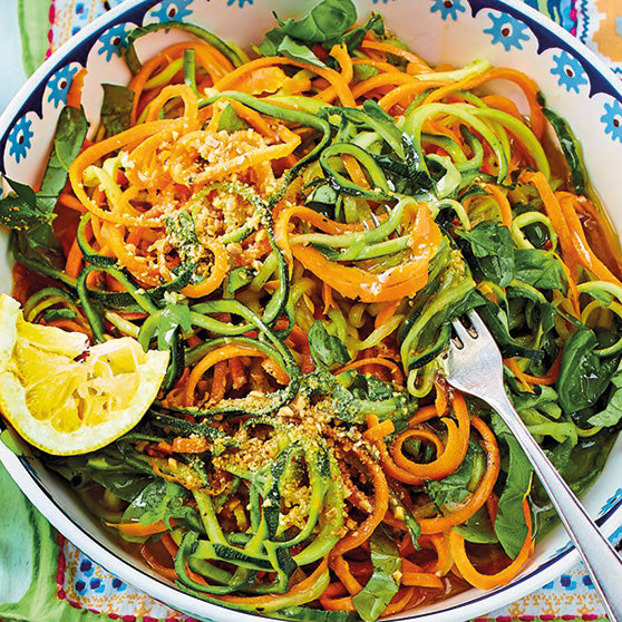 Bunte Gemüsespaghetti aus Zucchini und Karotten mit frischen Kräutern.