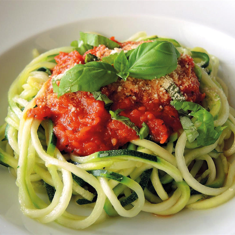 Zucchini-Spaghetti mit Tomatensoße, Basilikum und Parmesan.