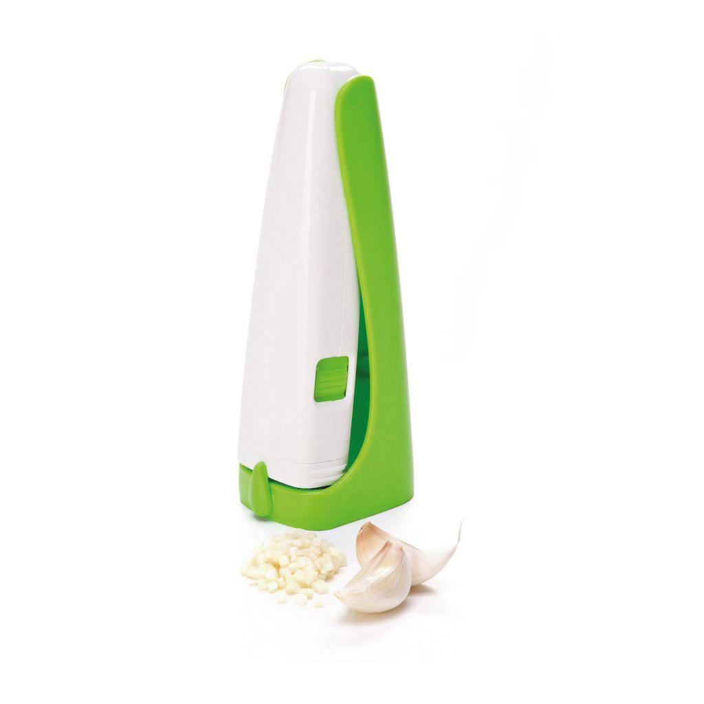 Knoblauch-Hexe aufgestellt mit gehacktem Knoblauch und zwei ganzen Knoblauchzehen dabei liegend