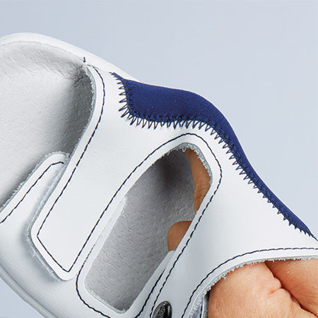 Detailaufnahme eines weißen Handschuhs mit blauer Naht, offener Fingerpartie und verstärktem Material.