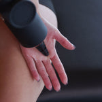 Anwendung einer Massagepistole im Bereich der Hand