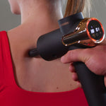 Massagepistole mit Bulletaufsatz am oberen Rücken