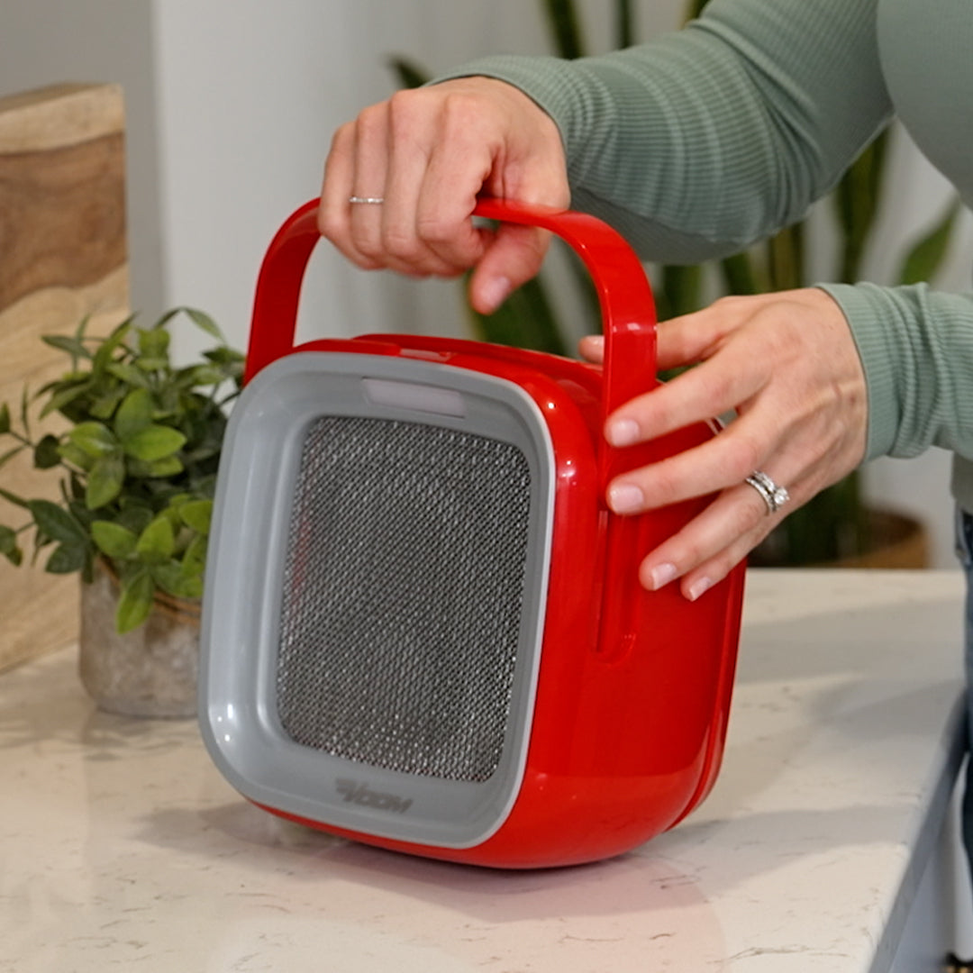 Eine Person greift denLivington AirVac am integrierten Tragegriff, um das kompakte Gerät bequem zu transportieren