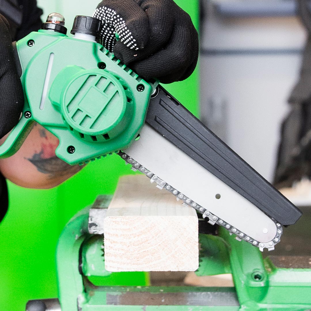 Mini-Kettensäge mit 14 cm Sägeschwert schneidet Holz auf Werkbank