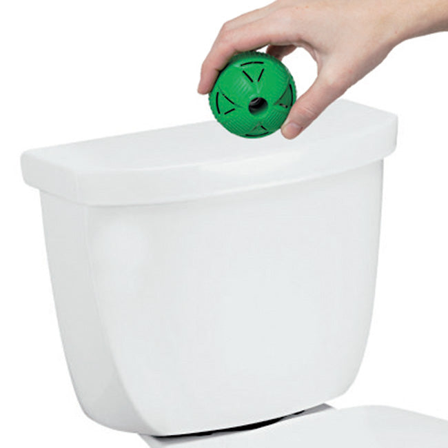 Eine grüne WC-Kugel wird in einen Spülkasten eingesetzt.