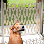 Ausziehbare Sicherheitswand aus Kunststoff im Türrahmen – ein Hund sitzt davor, zur Abgrenzung von Wohn- und Außenbereich.