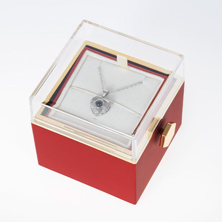 Rote Box mit transparentem Deckel zeigt ein Silberherz-Collier im weißen Einsatz.