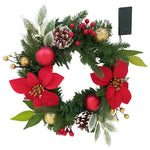 Weihnachtskranz mit roten Blüten, Tannenzweigen, Kugeln, Zapfen und Batteriefach.