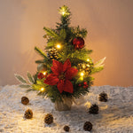 Beleuchteter Mini-Weihnachtsbaum mit roten Blüten, Zapfen und Kugeln – festliche Dekoration für jeden Raum.