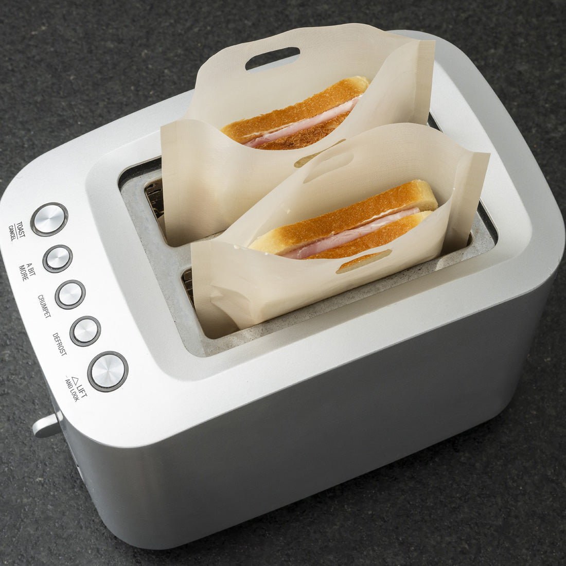 Zwei Sandwiches im Toaster, eingeschoben in hitzebeständige Beutel.