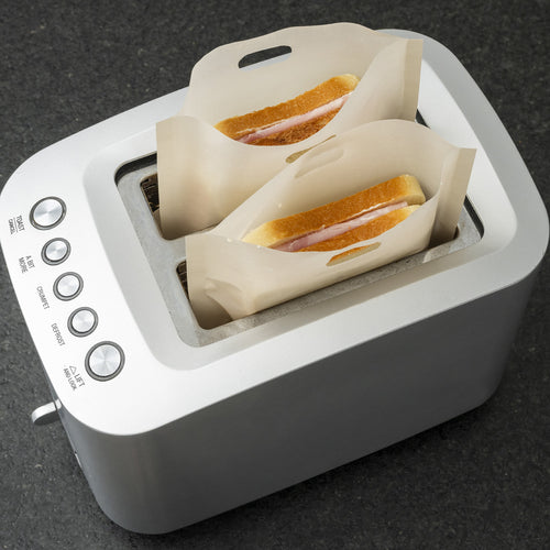Zwei Sandwiches im Toaster, eingeschoben in hitzebeständige Beutel.