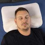 Ein Mann liegt auf dem Rücken auf einem ergonomischen Kissen.