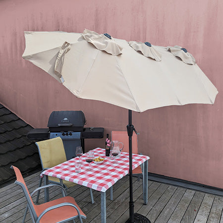 Extrabreiter, aufgespannter sandfarbener Sonnenschirm auf Terrasse